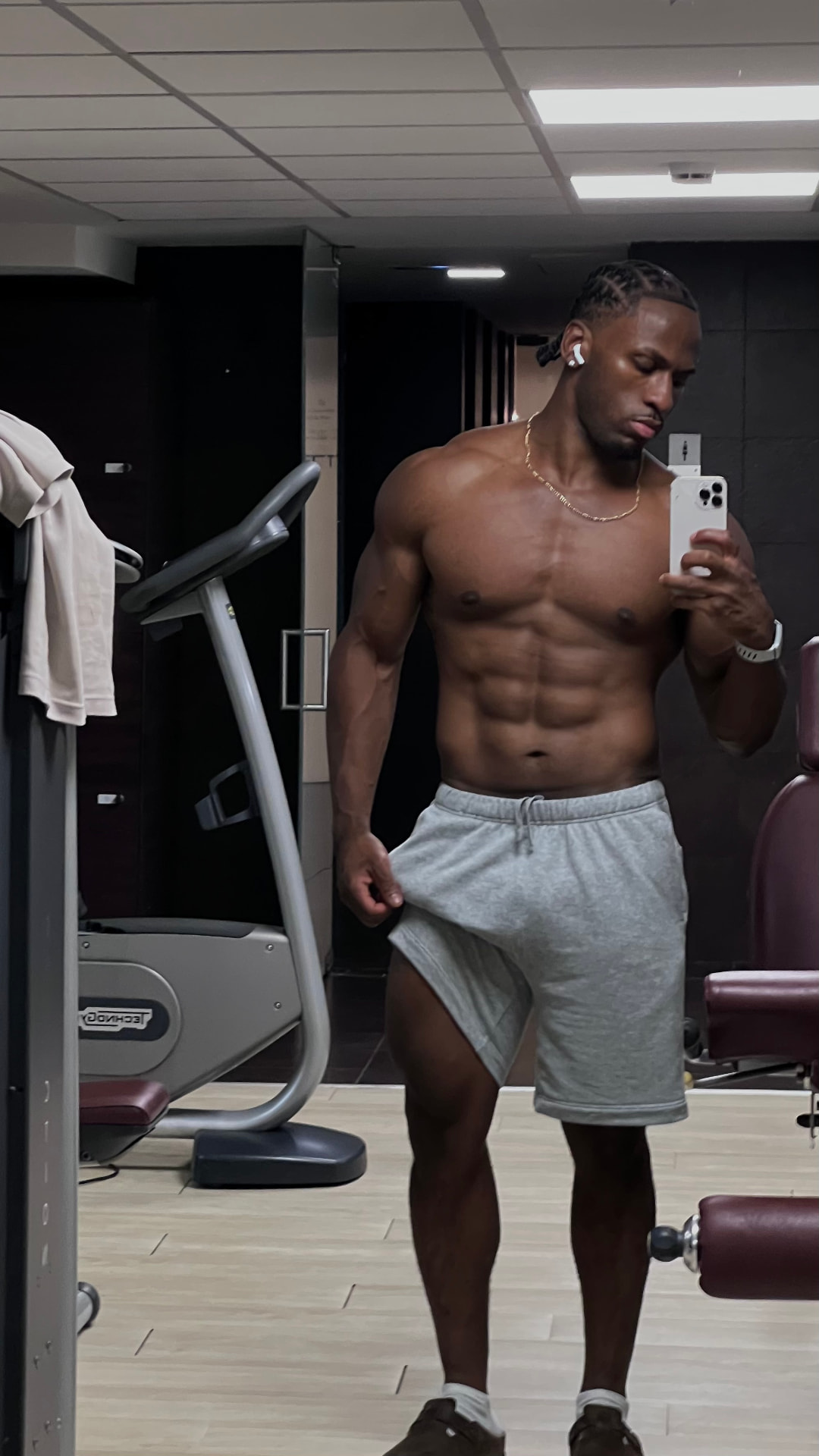 Coach in a gym showing a lean, muscular physique